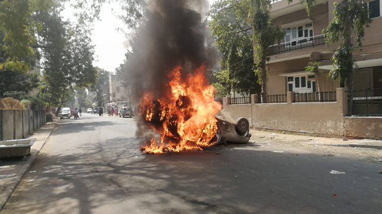 Protesters burn a car at Vadaj, Ahmedabad on February 18. Credit: Twitter