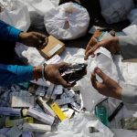People segregate expired medicines outside a chemist store in New Delhi
