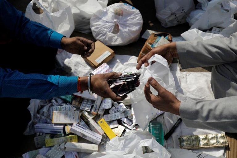 People segregate expired medicines outside a chemist store in New Delhi