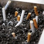 Cigarette butts are seen at an ash tray at a smoking area outside a shopping mall in Beijing, China