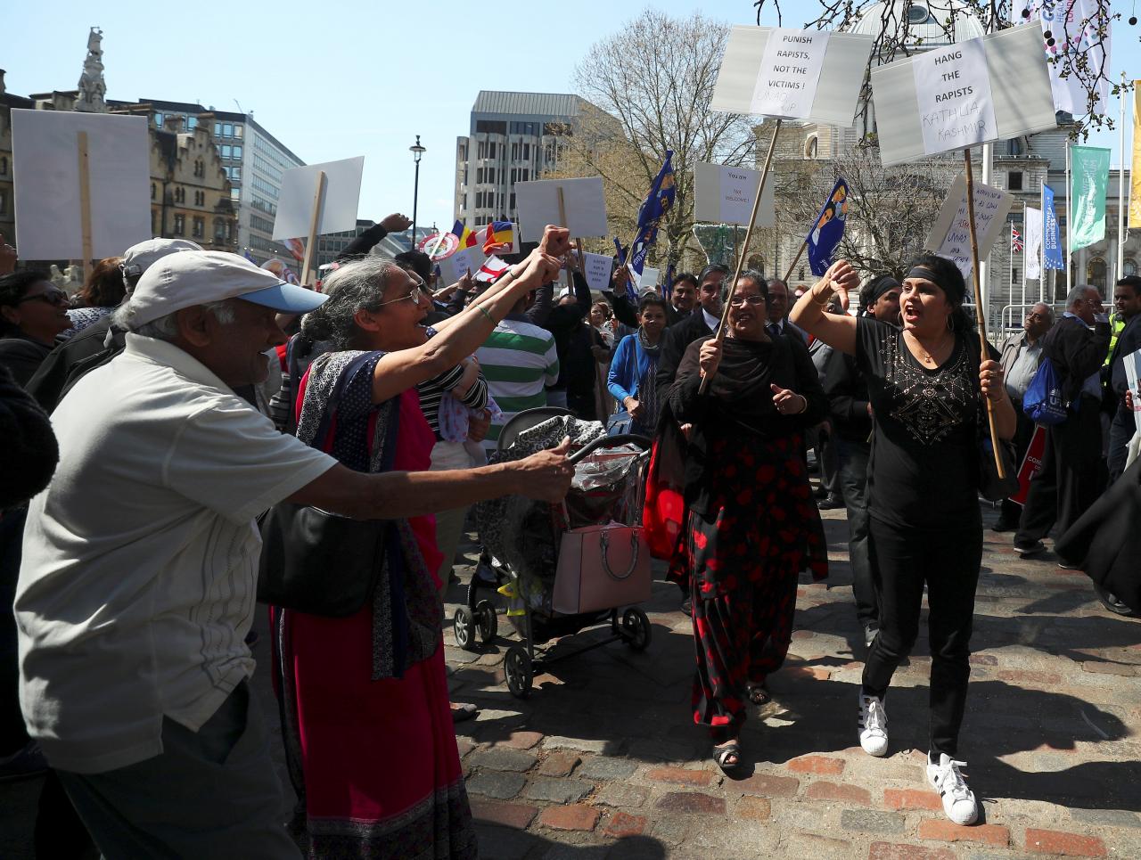 Demonstrator holding placards and protesting against India's Prime Minister Narendra Modi walk past supporters of Prime Minister in Parliament Square, London, Britain, April 18, 2018. Credit: Reuters/Hannah McKay
