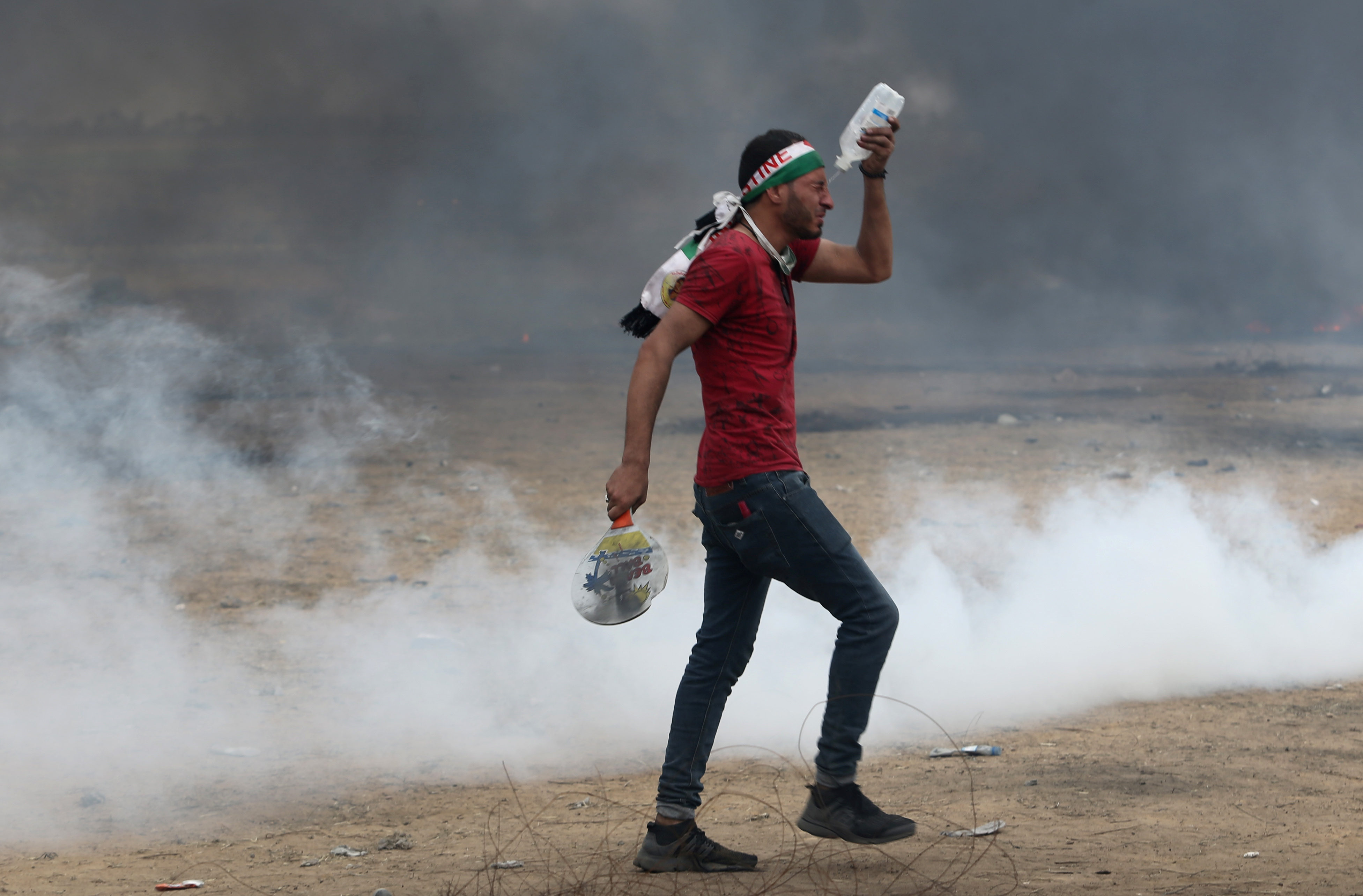 A demonstrator reacts to tear gas fired by Israeli troops during a protest where Palestinians demand the right to return to their homeland, at the Israel-Gaza border in the southern Gaza Strip, May 4, 2018. Credit: Reuters/Ibraheem Abu Mustafa