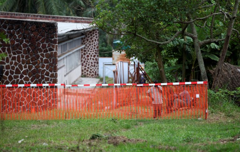 Medical workers are seen through a cordon ribbon in the area, near the isolation facility prepared to receive suspected Ebola cases, at the Mbandaka General Hospital, in Mbandaka, Democratic Republic of Congo May 20, 2018. Credit: Reuters/Kenny Katombe