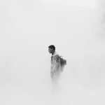 A man stands shrouded in smoke in London, UK. Credit: Brunel Johnson/Unsplash
