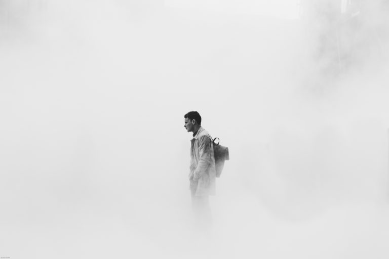 A man stands shrouded in smoke in London, UK. Credit: Brunel Johnson/Unsplash