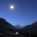 The first light of dawn illuminates Mount Everest as the moon shines above and a toilet block is seen in the foreground in the Tibet Autonomous Region, China, April 29, 2008. Credit: Reuters/David Gray/Files
