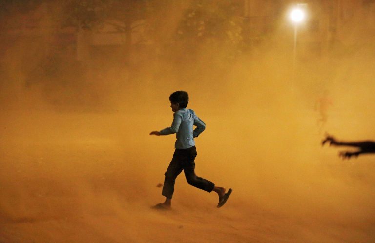 A boy runs for cover during a dust storm in New Delhi, India May 13, 2018. Credit: Reuters/Adnan Abidi
