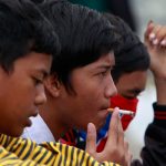 An Indonesian student smoke a cigarette at railway track in Jakarta. Credit: Reuters