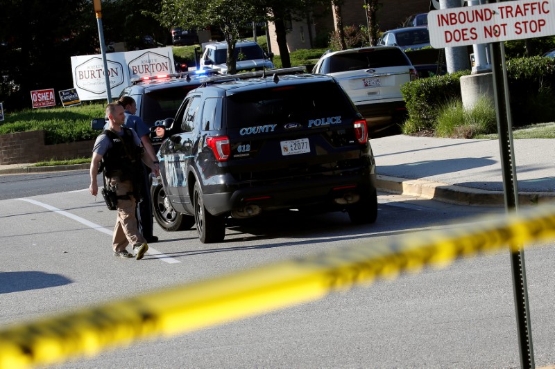 Police walk past a vehicle near a shooting scene after a gunman opened fire at the Capital Gazette newspaper in Annapolis, Maryland, US June 28, 2018. Credit: Reuters/Joshua Roberts