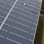 FILE PHOTO: File photo of workers cleaning photovoltaic panels inside a solar power plant in Gujarat