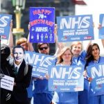 FILE PHOTO: NHS staff hold banners and placards during a posed protest in central London
