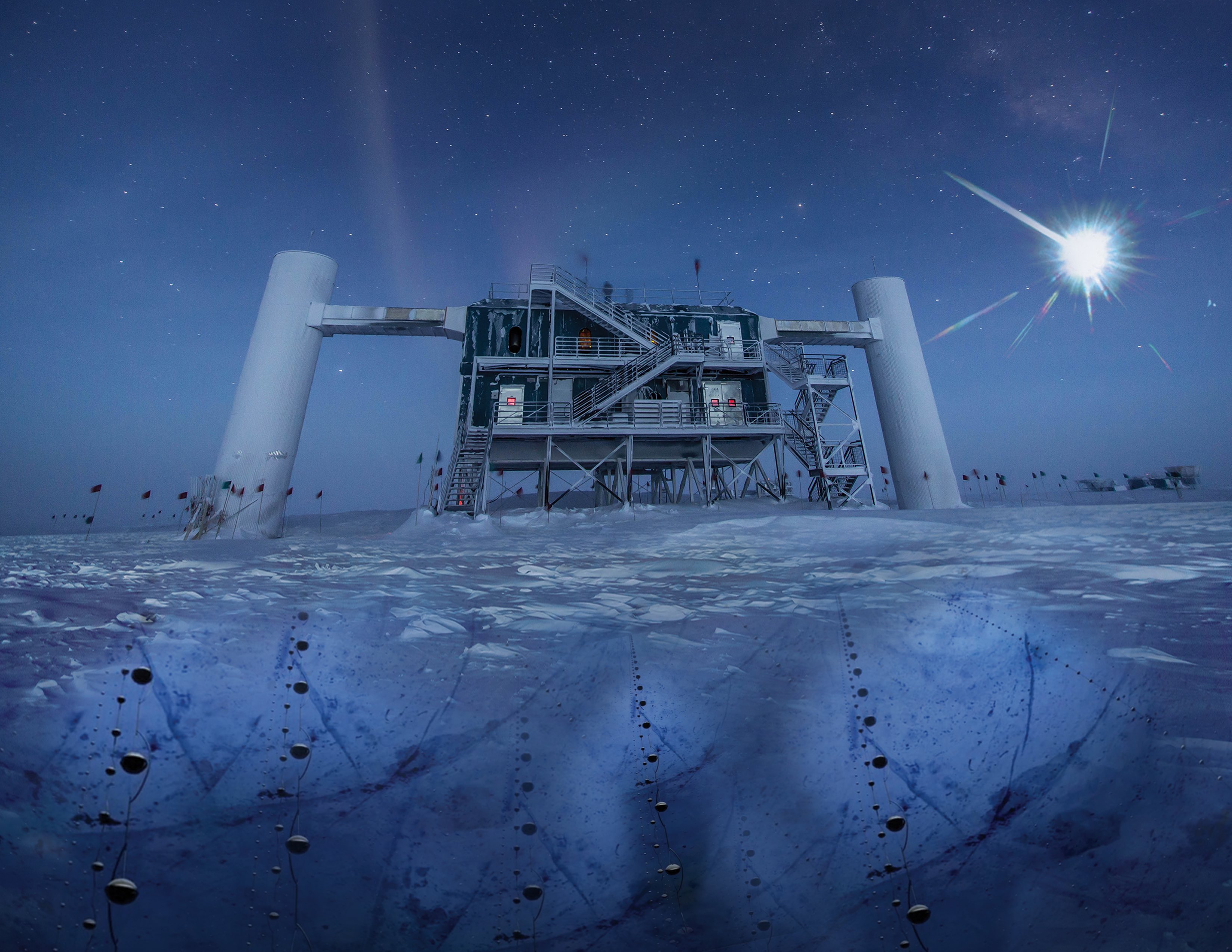 In this artistic composition, based on a real image of the IceCube Lab at the south pole, a distant source emits neutrinos that are detected below the ice by IceCube sensors. Credit: IceCube Collaboration/NSF