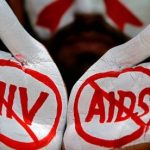 A student displays his hands painted with messages as he poses during an HIV/AIDS awareness campaign to mark the International AIDS Candlelight Memorial, in Chandigarh