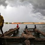 A boy walks through a damaged jetty as pre-monsoon clouds gather above the Vembanad Lake in Kochi, India, May 11, 2018. Credit: Reuters/Sivaram V/Files