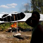 A man reacts as an illegal logging camp is burnt during "Operation Green Wave" conducted by the Brazilian Institute for the Environment and Renewable Natural Resources, or Ibama, to combat illegal logging in Apui, in the southern region of the state of Amazonas, Brazil, July 28, 2017. Credit: Reuters/Bruno Kelly/File Photo