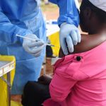 A Congolese health worker administers Ebola vaccine to a woman who had contact with an Ebola sufferer in the village of Mangina