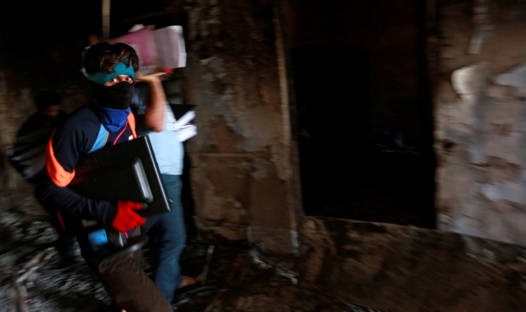 A worker holds the remaining files from the fire of the municipality building of Basra, Iraq September 6, 2018. Credits: Reuters/Alaa al-Marjani
