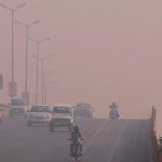 Commuters make their way amidst smog on a flyover in New Delhi