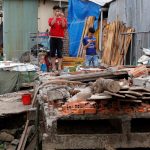Men stand at their collapsed houses damaged by landslide along Mekong river in Can Tho city, Vietnam December 17, 2018. Picture taken December 17, 2018. Credit: REUTERS/Kham
