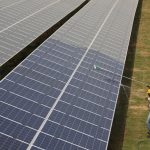FILE PHOTO: Workers clean photovoltaic panels inside a solar power plant in Gujarat