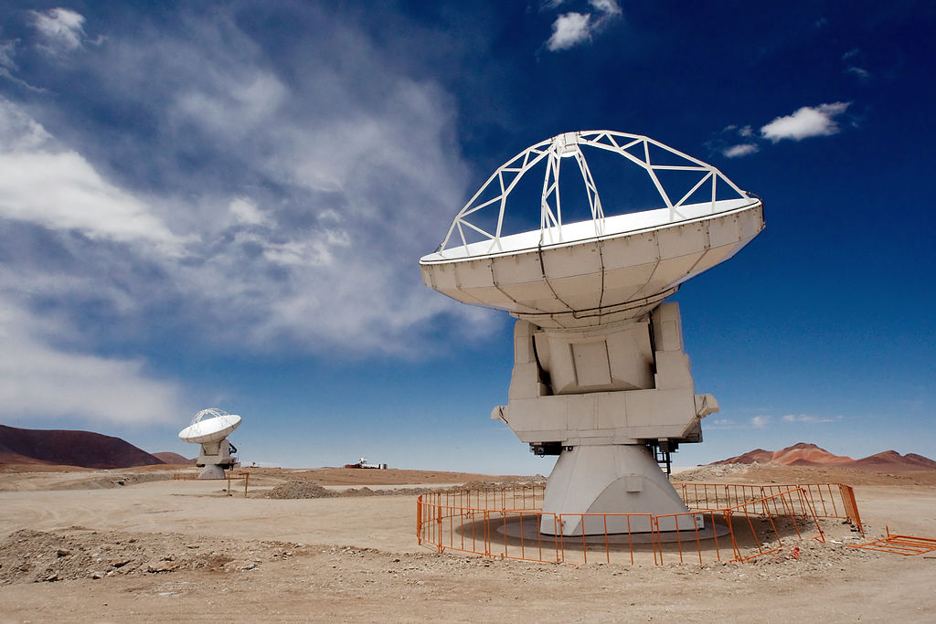 Two of the Atacama Large Millimeter/submillimeter Array (ALMA) 12-metre antennas gaze at the sky at the observatory’s Array Operations Site (AOS), high on the Chajnantor plateau at an altitude of 5000 metres in the Chilean Andes. Caption and credit: Iztok Bončina/ESO, CC BY 4.0