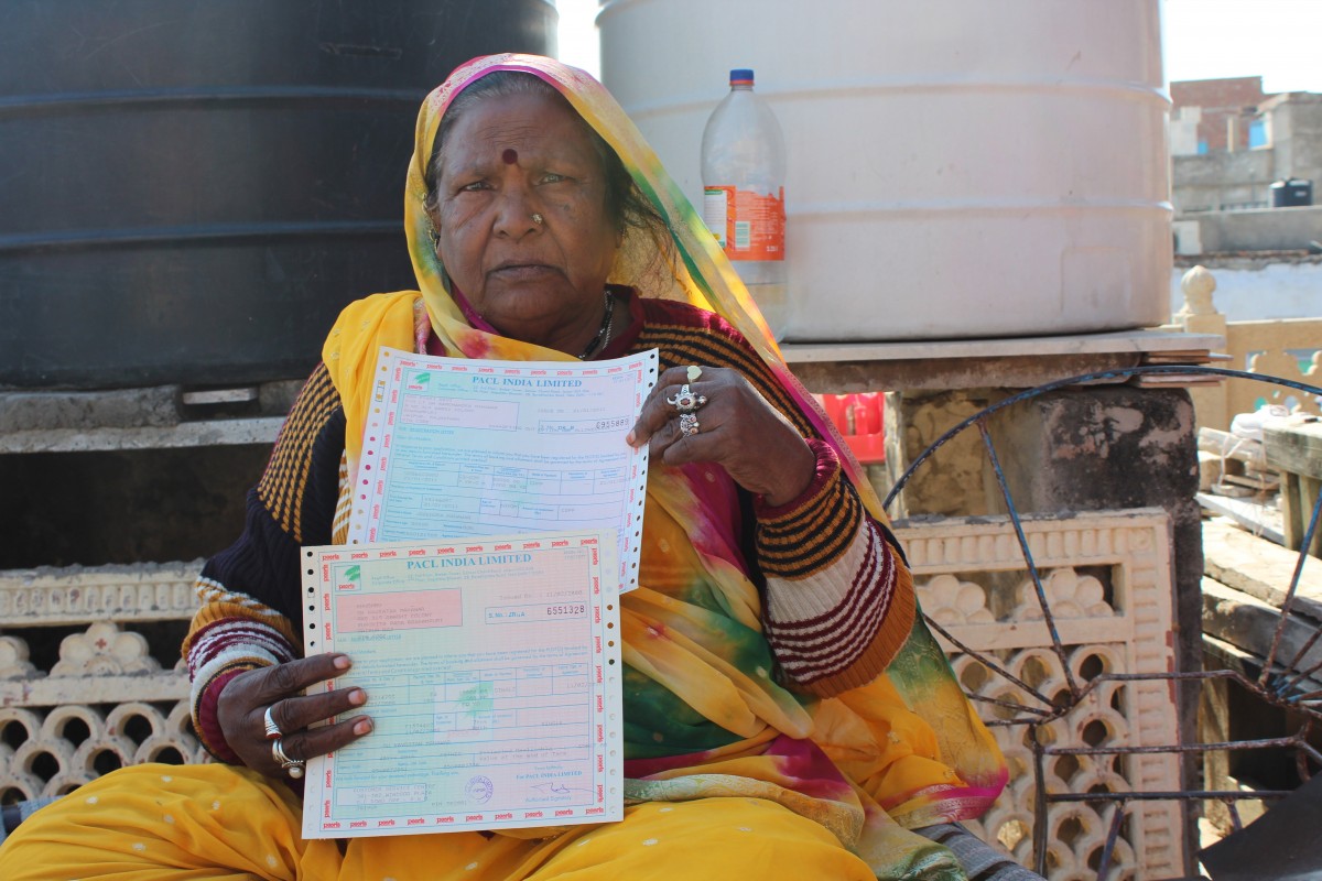 Ram Pyari holding her PACL investment certificates. Credit: Shruti Jain