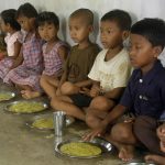 Children eat food at "anganwadi" (creche') centre in Kutnabari village
