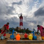 Residents fill their vessels with potable water from a hand pump at Marina beach, in Chennai on June 20. Photo: PTI