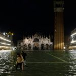 People walk in a flooded St.Mark's Square during a period of seasonal high water