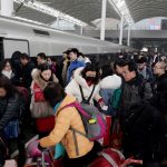 FILE PHOTO: File picture of travellers boarding a train at a railway station in China as the annual Spring Festival travel rush begins ahead of the Chinese Lunar New Year