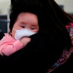 A child wears mask to prevent an outbreak of a new coronavirus at the Hong Kong West Kowloon High Speed Train Station, in Hong Kong