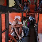 Migrant workers from Madhya Pradesh and Uttar Pradesh are seen sitting inside a bus as they prepare to depart, in Ahmedabad