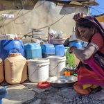 Sangeeta washing utensils outside her home