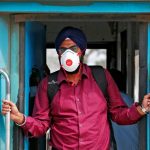 A-man-wearing-a-face-mask-as-a-precaution-against-the-spread-of-coronavirus-stands-in-a-train-at-a-railway-station-in-New-Delhi-India-March-16-2020.-Reuters-770x433