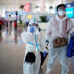 People wearing protective gear are seen at the Wuhan Tianhe International Airport