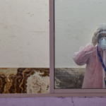 A medic wears a protective suit in the waiting room of the first drive-through sample collection site for possible COVID-19 patients, during the nationwide lockdown to curb the spread of coronavirus, at Lower Parel in Mumbai, Monday, April 13, 2020. Photo: PTI