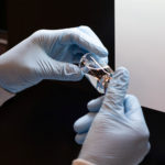 A lab technician visually inspects a filled vial of investigational remdesivir at a Gilead Sciences facility in La Verne
