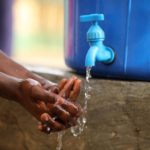 A student washes her hands after clean up at a school in Abuja