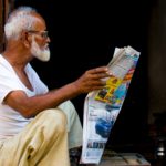 old-man-sitting-while-holding-newspaper-article-2248503