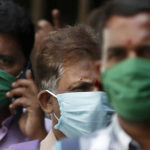 FILE PHOTO: Men wearing protective masks walk inside the premises of a hospital where a special ward has been set up for the coronavirus disease in Mumbai