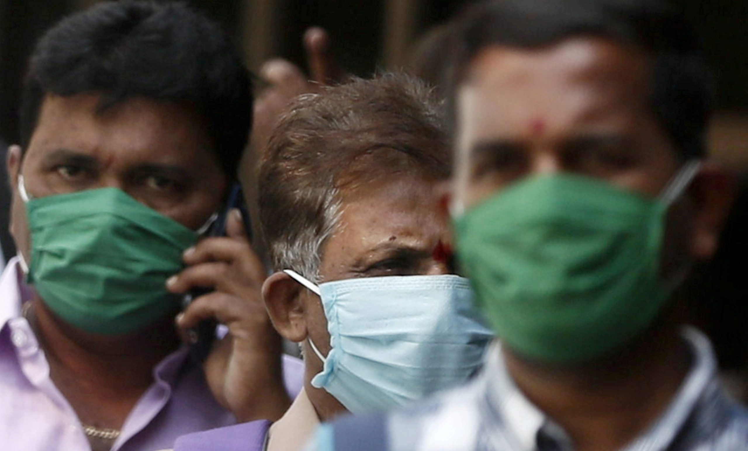 FILE PHOTO: Men wearing protective masks walk inside the premises of a hospital where a special ward has been set up for the coronavirus disease in Mumbai