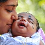 mother-kissing-child-on-cheek-1586257