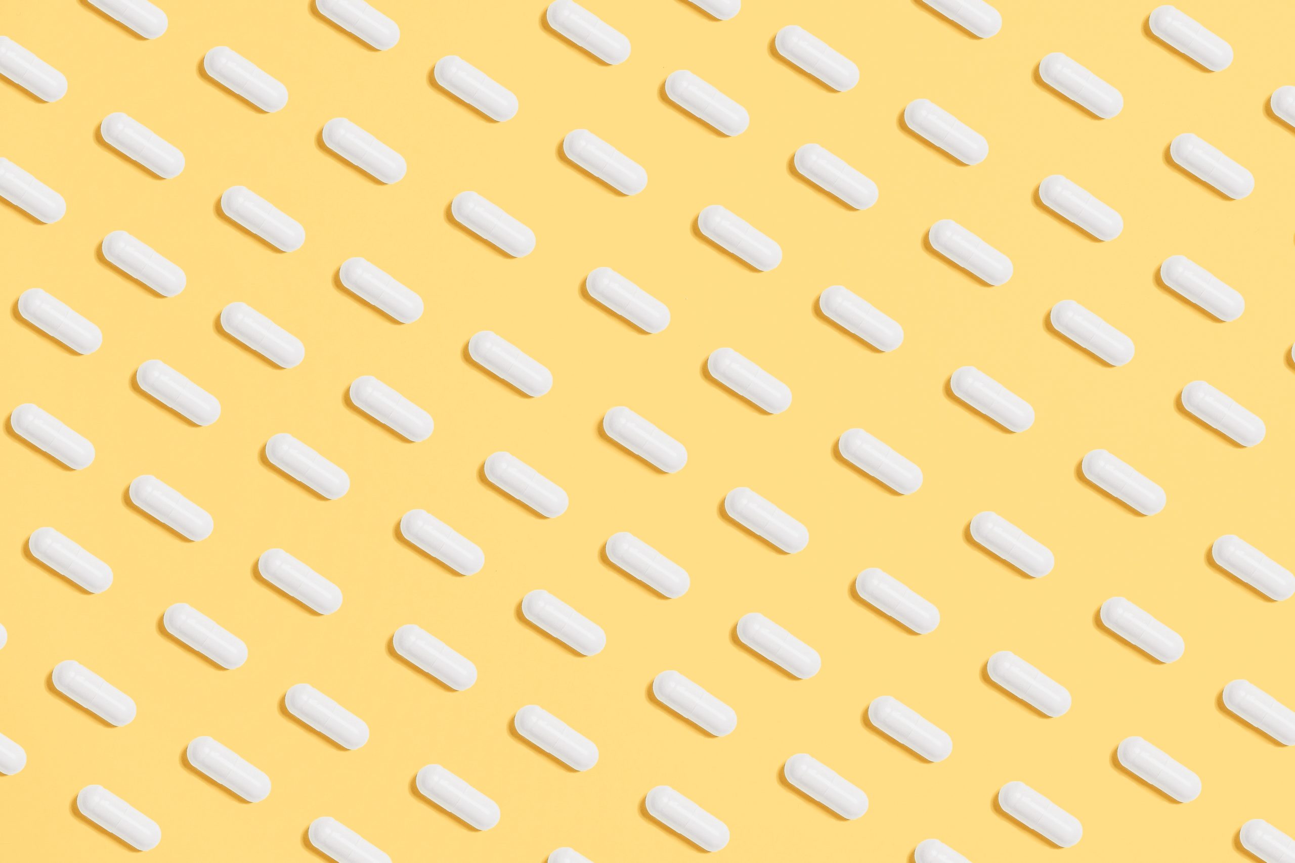 white-capsules-on-yellow-background-3683056