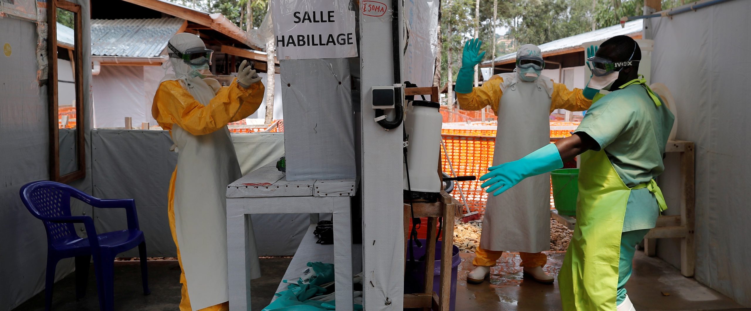 FILE PHOTO: Moise Vaghemi (L), 33, an Ebola survivor who works as a nurse, gets dressed in a protective suit as he prepares to start his shift at an Ebola treatment centre in Katwa