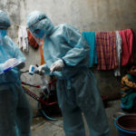 Healthcare workers write down details of residents in a slum during a check-up camp for the coronavirus disease (COVID-19) in Mumbai