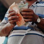 man-in-blue-and-white-stripe-polo-shirt-holding-banknote-4427643