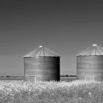 grayscale-photography-of-two-silo-on-grass-1058398f