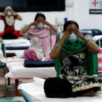 People suffering from the coronavirus disease (COVID-19) perform yoga inside a care centre for COVID-19 patients at an indoor sports complex in New Delhi
