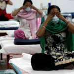 People suffering from the coronavirus disease (COVID-19) perform yoga inside a care centre for COVID-19 patients at an indoor sports complex in New Delhi