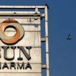 A bird flies past the logo of Sun Pharma installed on the facade of its corporate office in Mumbai